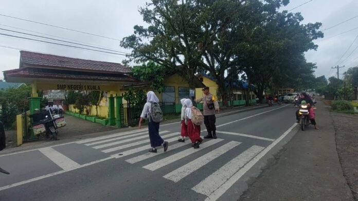 Peduli Keselamatan Siswa, Bhabinkamtibmas Polsek Kuala Turun Langsung Atur Lalu Lintas Pagi Hari